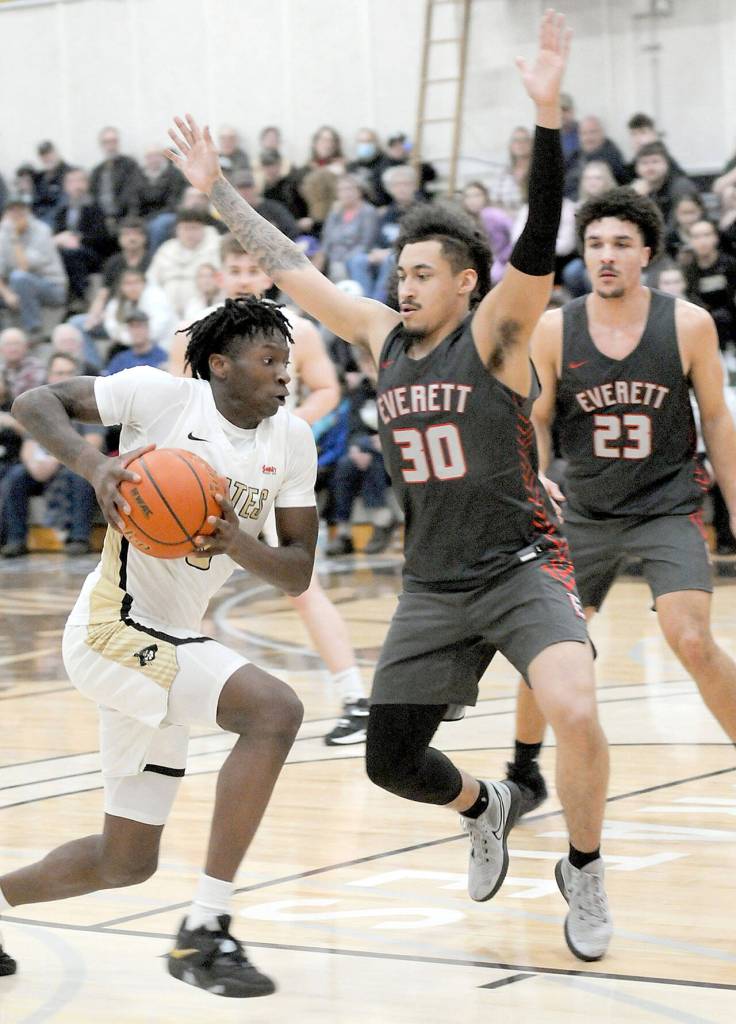 Peninsulas Ese Onakpoma charges to the lane as Everetts Tony MacArthur and Jadin Penigar, right, hold their ground on Wednesday at Peninsula College. (Keith Thorpe/Peninsula Daily News)