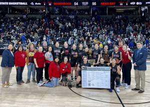 The Neah Bay girls basketball team celebrates winning the 1B state championship Saturday night in Spokane. (Bridget Mayfield/for the Peninsula Daily News)