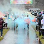 Participants in the 5K Sun Fun Color Run emerge from clouds of tempera paint while being pelted by rain and snow during Saturdays Sequim Sunshine Festival at Carrie Blake Park and the Albert Haller Play Fields with additional events at Pioneer Park. Inclement weather on Saturday forced organizers to move many entertainment events indoors. (Keith Thorpe/Peninsula Daily News)