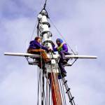 Workers install rigging atop the 60-foot-tall foremast on the 133-year-old historic tall ship Adventuress. The ship has been on the hard at the Port Townsend Boat Haven since last December and is expected to go in the water by the end of the week. (Steve Mullensky/for Peninsula Daily News)
