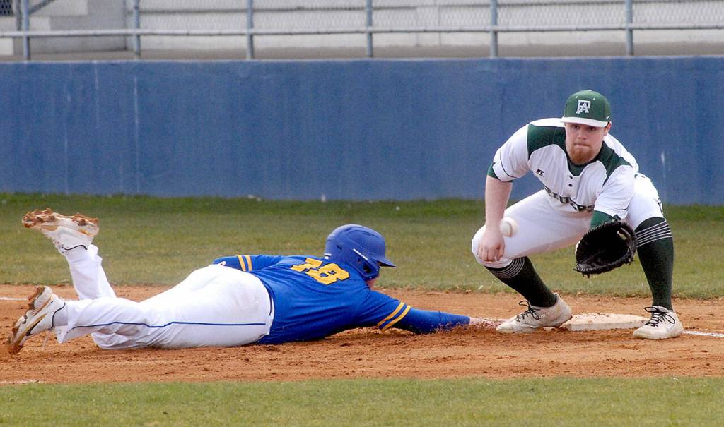 Port Angeles first baseman Ezra Townsend receives the throw from the pitcher in a pick-off attempt on Bremertons Bryce Ells on Tuesday afternoon in Port Angeles. (Keith Thorpe/Peninsula Daily News)