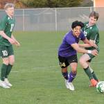 KEITH THORPE/PENINSULA DAILY NEWS Sequims Evan Cisneros, center, pushes past Port Angeles Jacob Weaver, right, as Weavers teammate, Matthew Miller, looks on at left on Thursday in Port Angeles.