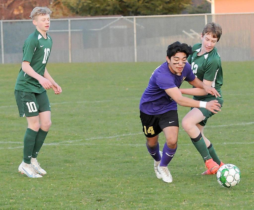 KEITH THORPE/PENINSULA DAILY NEWS Sequims Evan Cisneros, center, pushes past Port Angeles Jacob Weaver, right, as Weavers teammate, Matthew Miller, looks on at left on Thursday in Port Angeles.