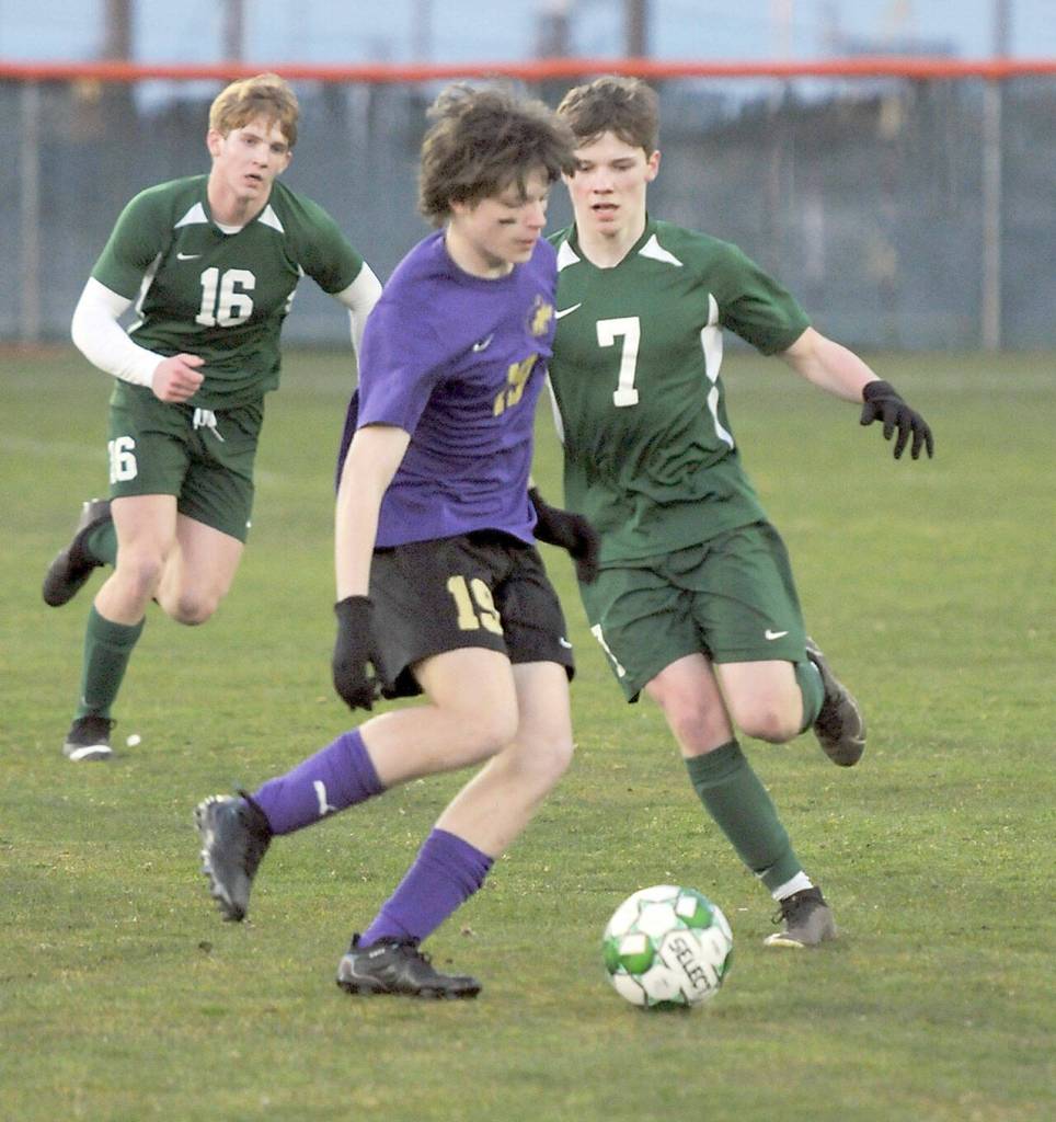 KEITH THORPE/PENINSULA DAILY NEWS Sequims Finn Braaten, center, looks for a way past Port Angeles Kaleb Gagnon, right, as teammate Zak Alton comes up from behind on Thursday night in Port Angeles.