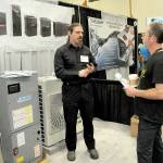 John Graham of Sequim, right, talks with Richard Fife, owner of Port Angeles-based Strait Comfort Systems, at the 38th annual KONP Home Show on Saturday at Port Angeles High School. The event featured dozens of exhibitors and displays centered on homes, home improvement and lifestyles. (Keith Thorpe/Peninsula Daily News)