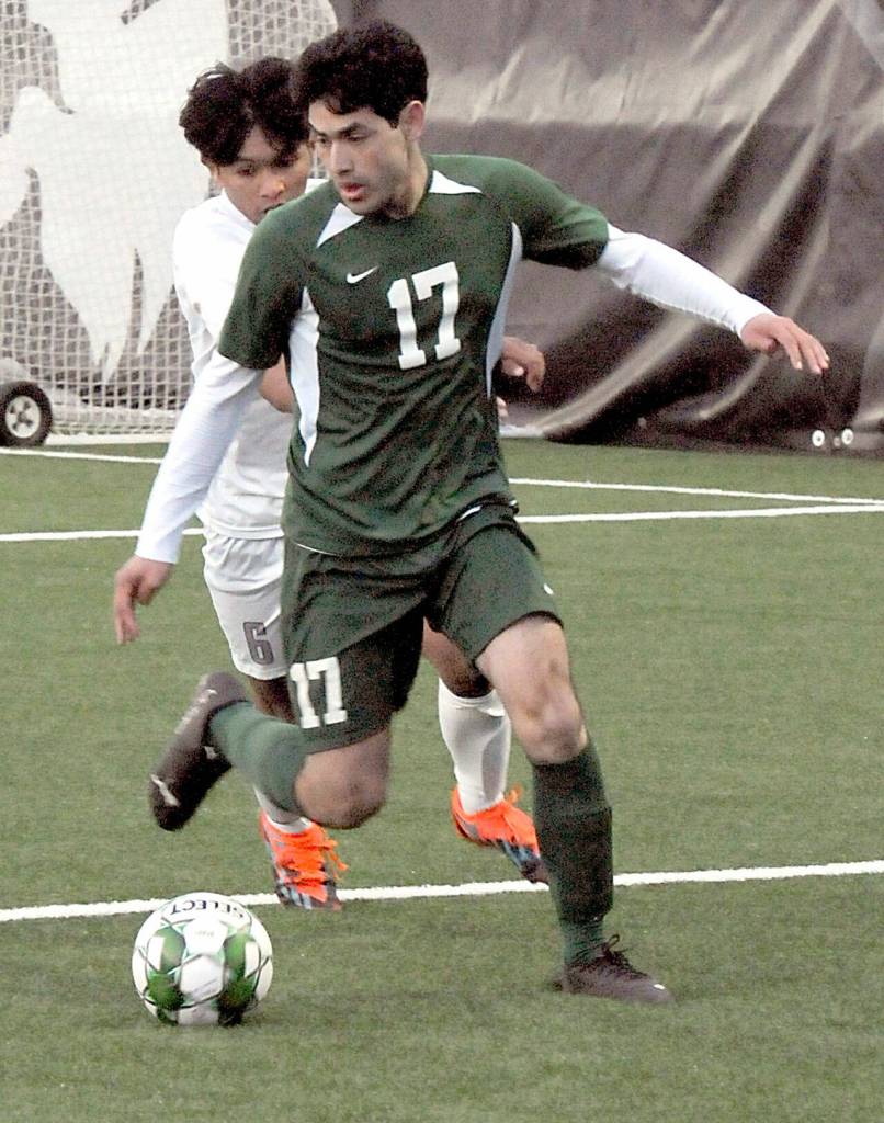 KEITH THORPE/PENINSULA DAILY NEWS Port Angeles Caim Valles, front, slips past the defense of Olympics Chase Guerrero on Thursday night in Port Angeles.
