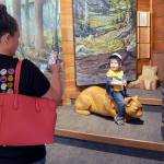 Savanna Hoglund of Spokane takes a photo of her son, Lincoln Hoglund, 2, as hit sits on a wooden cougar sculpture in the Discovery Room on Tuesday at the Olympic National Park Visitor Center in Port Angeles. The center features a variety of displays that provide a sampling of what can be found within the park, as well as interactive exhibits for children. (Keith Thorpe/Peninsula Daily News)