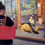 Savanna Hoglund of Spokane takes a photo of her son, Lincoln Hoglund, 2, as hit sits on a wooden cougar sculpture in the Discovery Room on Tuesday at the Olympic National Park Visitor Center in Port Angeles. The center features a variety of displays that provide a sampling of what can be found within the park, as well as interactive exhibits for children. (Keith Thorpe/Peninsula Daily News)