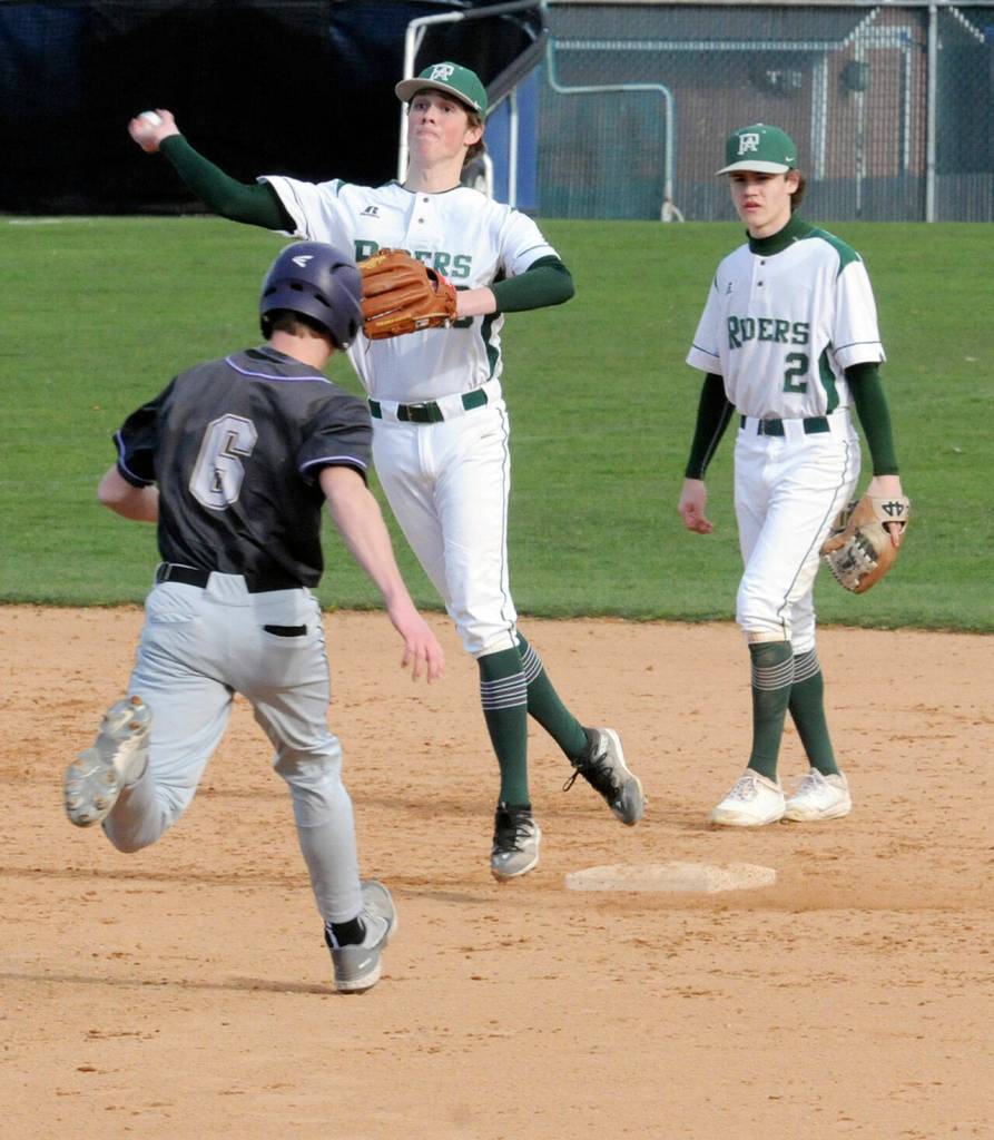 KEITH THORPE/PENINSULA DAILY NEWS Port Angeles second baseman Kole Acker, center, throws to first after forcing out North Kitsaps Ethan Gillespie at second while Ackers teammate, Alex Angevine, stands as backup during Tuesdays game in Port Angeles.