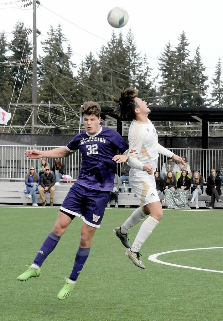 The University of Washingtons Keegan Yorke, left, and Peninsulas Inchun Han compete for a header on Saturday in Port Angeles. (Keith Thorpe/Peninsula Daily News)