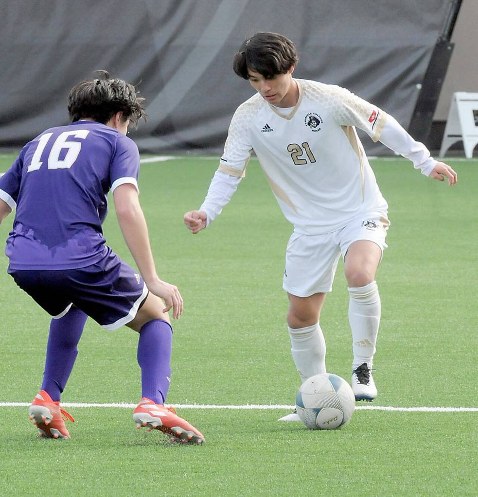 KEITH THORPE/PENINSULA DAILY NEWS Peninsulas Tsubasa Abe, right, looks for a way around the University of Washingtons Woody Manum during Saturdays exhibition match in Port Angeles.