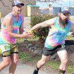 Subalpine Tees Race Team runner Chris Cummings hands the baton to brother and teammate Jon Cummings at the Port Angeles Yacht Club transfer zone during Saturday's Frosty Moss Relay. The event that stretches from the Sol Duc Valley to Blyn featured 48 relay teams and four individuals. The Subalpine Tees finished sixth in the 80-mile race. (Dave Logan/for Peninsula Daily News)