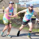 Subalpine Tees Race Team runner Chris Cummings hands the baton to brother and teammate Jon Cummings at the Port Angeles Yacht Club transfer zone during Saturdays Frosty Moss Relay. The event that stretches from the Sol Duc Valley to Blyn featured 48 relay teams and four individuals. The Subalpine Tees finished sixth in the 80-mile race. (Dave Logan/for Peninsula Daily News)