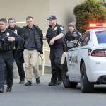 Police escort a man, center, who was alleged to have brandished a gun in the 48º North Waterfront Restaurant next to the Red Lion Hotel on Saturday. The incident prompted evacuation of the restaurant while closing down the 100 block of North Lincoln Street. (Keith Thorpe/Peninsula Daily News)