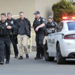 Police escort a man, center, who was alleged to have brandished a gun in the 48º North Waterfront Restaurant next to the Red Lion Hotel on Saturday. The incident prompted evacuation of the restaurant while closing down the 100 block of North Lincoln Street. (Keith Thorpe/Peninsula Daily News)