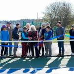 Port Townsend city council member, Monica Mick-Hagger and Port Townsend Pickleball Club president Lynn Pierle (cq) cut the ribbon to dedicate the Mountain View Pickleball courts to the City of Port Townsend in a ribbon cutting on Wednesday at the club. Others looking on are members of the club board of directors and city manager John Mauro, holding the microphone, Carrie Hite, Director of Parks and Recreation strategy, holding the ribbon and to her left is director of parks facilities, Michael Todd. The club now has 219 members on the roster. (Steve Mullensky/for Peninsula Daily News)