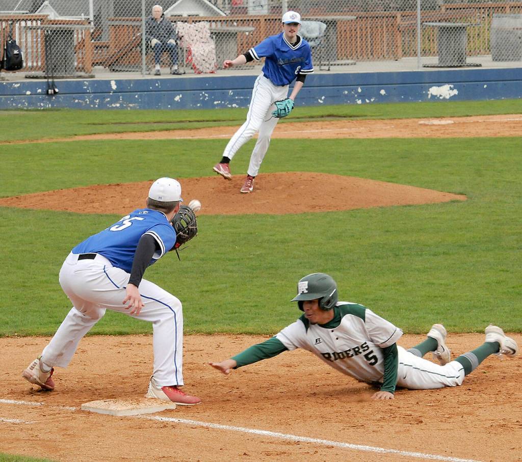 Port Angeles Brian Guttormson, right, dives back to first during a pickoff attempt from North Mason pitcher Nolan McGanney to first baseman Kingston Serebryakov on Tuesday in Port Angeles. (Keith Thorpe/Peninsula Daily News)