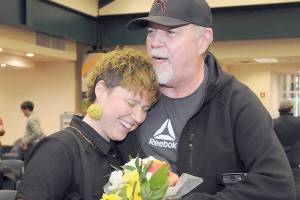 Jaiden Dokken, Clallam Countys first poet laureate, receives a hug and flowers from their father Mark Dokken of Port Angeles after Jaiden was inaugurated to their two-year post on Tuesday at the Port Angeles Public Library. (Keith Thorpe/Peninsula Daily News)
