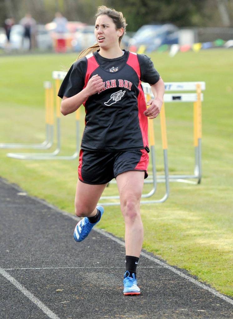 Ryana Moss of Neah Bay checks her time crossing the finish line the girls 1,600-meter run on Wednesday. (Keith Thorpe/Peninsula Daily News)