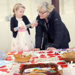 Ida Shantz, 5, of Port Angeles looks over a sheet of stenciled letters with her grandmother, Patricia Kessler of Woodburn, Ore., at a cardboard crown craft table during Saturdays Barn Dance at the Clallam County Fairgrounds to benefit the Five Acre School north of Sequim. The dance also included food, entertainment, childrens activities and a silent auction. (Keith Thorpe/Peninsula Daily News)