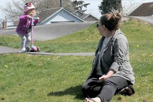 Ellori Rotter, 3, of Port Angeles scoots around the Port Angeles Pump Track at Erickson Playfield in Port Angeles as her aunt, Alison Schmidt of Marysville, keeps watch on Thursday. In a break from a spring of below-average temperatures, several days of seasonable temperatures are forecast for most of Western Washington through the weekend.