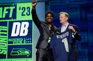 Illinois defensive back Devon Witherspoon, left, stands with NFL Commissioner Roger Goodell after being chosen by the Seattle Seahawks with the fifth overall pick during the first round of the NFL football draft, Thursday, April 27, 2023, in Kansas City, Mo. (AP Photo/Jeff Roberson)
