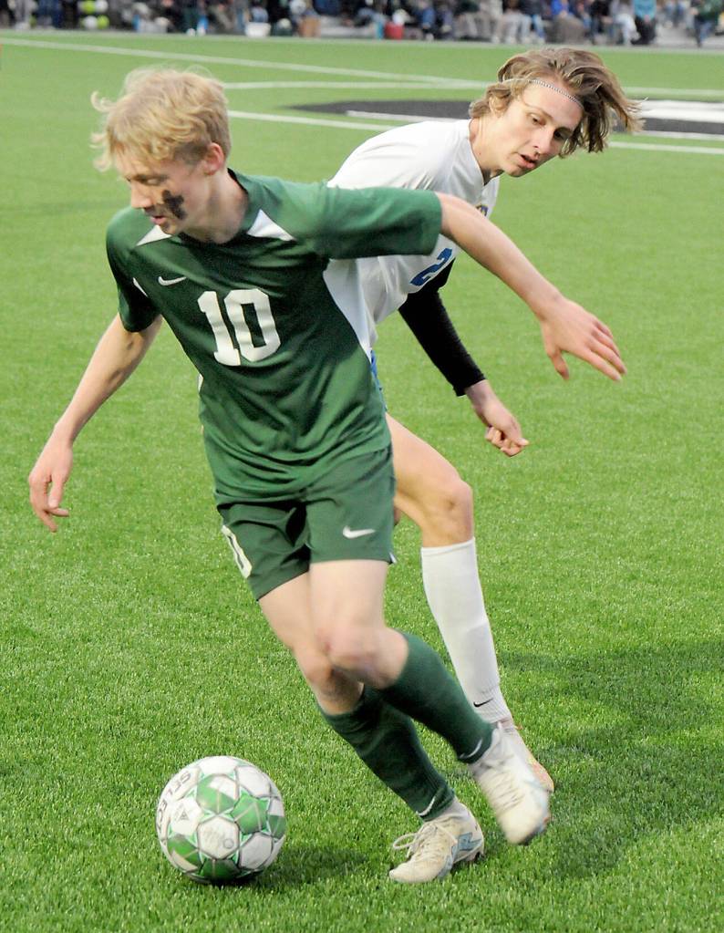 KEITH THORPE/PENINSULA DAILY NEWS Port Angeles Matthew Miller, front, slips past Bremertons Evan Falk during Thursdays match at Peninsula College.