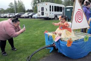Lesley Welch of Sequim takes a photo of her daughter, Avani Welch, 1, on a Moana-themed mini float during Saturdays Irrigation Festival Kids Parade at the Haller Athletic Fields in Sequim. The float was awarded grand prize by the judges, taking top honors in the parade. (Keith Thorpe/Peninsula Daily News)