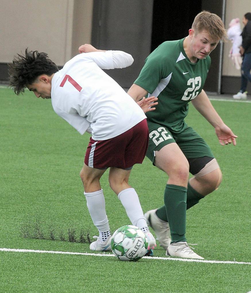 KEITH THORPE/PENINSULA DAILY NEWS
Port Angeles' Eli Fischer, right, watches for his opening as the ball slips past Kingston's Daniel Moran on Saturday in Port Angeles.