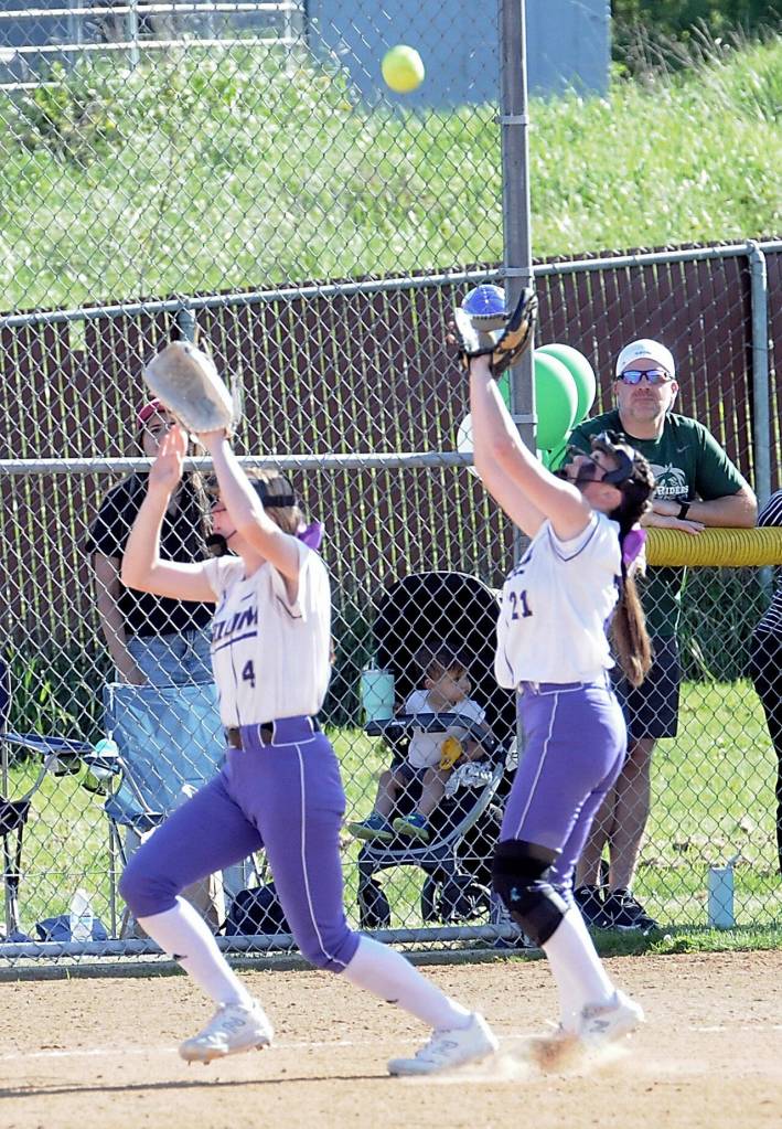 Sequims Ava Ritter, left, and Hannah Bates both reach for a pop fly against Port Angeles with Bates eventually making the catch on Friday in Port Angeles. (Keith Thorpe/Peninsula Daily News)