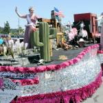 Port Townsend Rhody Festival royalty, Queen Melody Douglas, left, and Princess Paige Govia wave to the Irrigation Festival Grand Parade crowds from their float, driven by Bliss Morris, on Saturday. (Keith Thorpe/Peninsula Daily News)