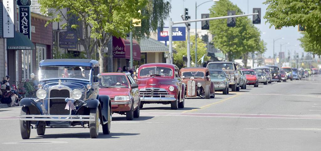 A procession of vintage and antique cars makes its way down Washington Avenue as part of the Irrigation Festival Classic Cruise & Show car show on Saturday. (Keith Thorpe/Peninsula Daily News)