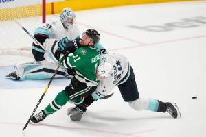Dallas Stars center Luke Glendening (11) is knocked down on an attack by Seattle Kraken defenseman Jamie Oleksiak (24) as  Kraken goaltender Philipp Grubauer (31) defends against the puck in the third period of Game 7 of an NHL hockey Stanley Cup second-round playoff series, Monday, May 15, 2023, in Dallas. (AP Photo/Tony Gutierrez)