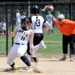 Rainier assistant coach Kayla Mounts, right, helps the umpire with the safe call at first base as Mountaineers runner Brooklyn Swenson reaches first on a wild throw. Forks first baseman Kaidence Rigby reaches for the ball in the dirt during the game played at Borst Park in Centralia, where Forks defeated Rainier 6-2 in 2B District 1/4 play. (Lonnie Archibald/for Peninsula Daily News)