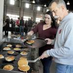 Port Angeles Fire Department paramedics Kristin Fox, left, and Brian Gerdes flip pancakes during the departments annual pancake breakfast on Saturday at the fire hall. The event, which included a complete breakfast with beverage, was a fundraiser for fire department scholarships and community outreach. (Keith Thorpe/Peninsula Daily News)