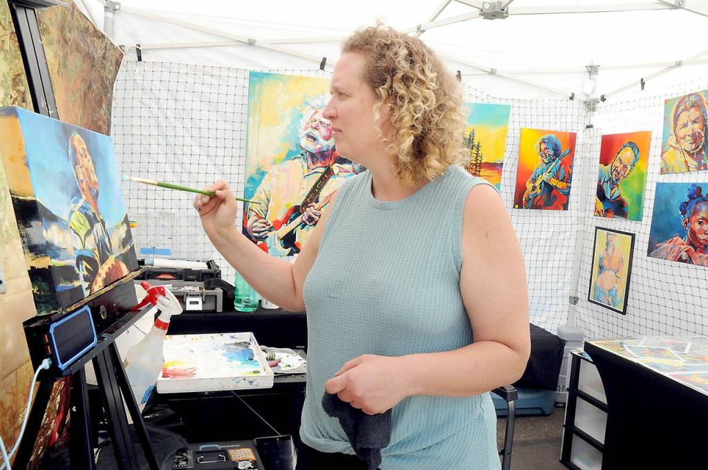 Frida Hass of Kingston-based Frida Hass Studios works on a painting during Fridays Juan de Fuca Festival Artisan Street Fair outside Vern Burton Community Center. (Keith Thorpe/Peninsula Daily News)