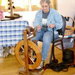 Debi Breitbach-Glass, of The Shepherds Fold, does some spinning on an old fashioned spinning wheel at the festival Monday. (Dave Logan/For Peninsula Daily News)