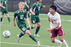 Port Angeles Matthew Miller, left, chases a loose ball ahead of Kingstons Edwin Vallecillo, right in a match this season in Port Angeles. (Keith Thorpe/Peninsula Daily News)