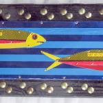 Loran Scruggs work at Port Townsend Gallery is with recycled materials, tin cans and bottle caps attached to plywood.