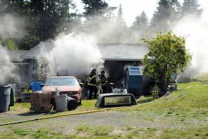 Smoke billows from a garage 71 S. Benson Road near Port Angeles on Wednesday. (Keith Thorpe/Peninsula Daily News)