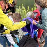 Rescuers in Jefferson County assist a woman on Wednesday who went looking for a hiker reported missing on Monday. The woman was injured attempting to cross the Duckabush River and transported to Jefferson Healthcare hospital in Port Townsend. (Brinnon Fire Department)