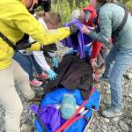 Rescuers in Jefferson County assist a woman on Wednesday who went looking for a hiker reported missing on Monday. The woman was injured attempting to cross the Duckabush River and transported to Jefferson Healthcare hospital in Port Townsend. (Brinnon Fire Department)