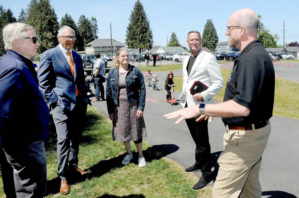 Port Angeles Dream Playground Foundation President Steve Methner, right, describes the volunteer effort that went into playground construction to, from left, State Rep. Steve Tharinger, Gov. Jay Inslee, Port Angeles Pump Track designer Catharine Copass and Port Angeles Parks Department director Cori Delikat during a gubenatorial visit to Erickson Playfield on Friday. (KEITH THORPE/PENINSULA DAILY NEWS)