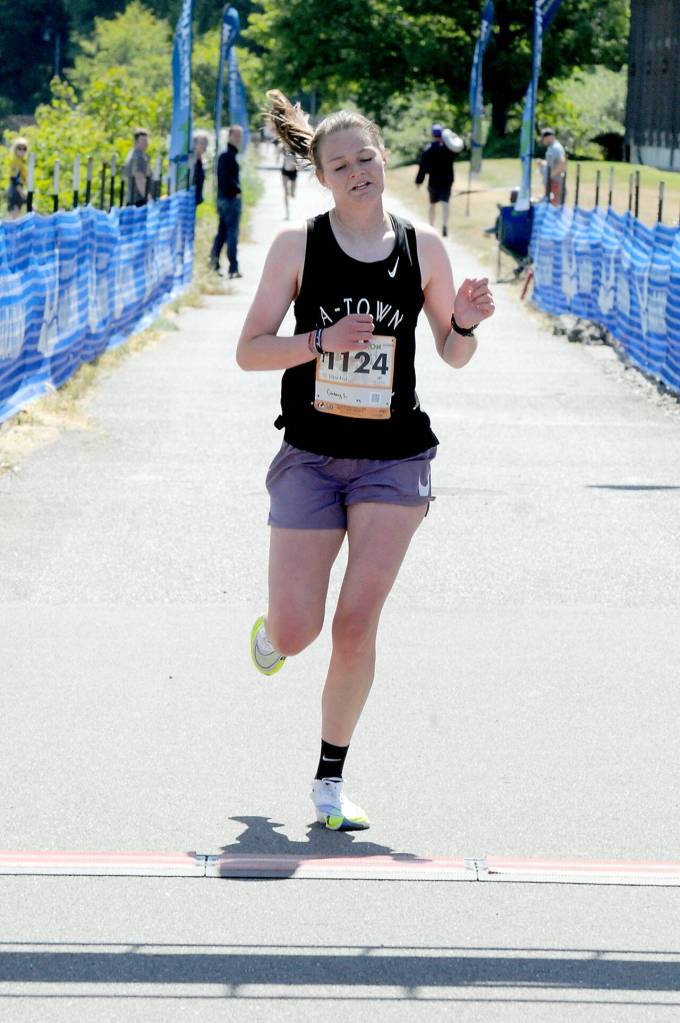 KEITH THORPE/PENINSULA DAILY NEWS Casey Lemrick of Anacortes, the top female winner of Saturdays 5k race crosses the finish line at Port Angeles City Pier.
