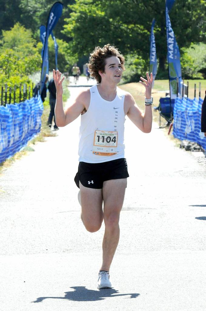 Kolin Keltner of Springfield, Mo., the overall winner of Saturdays 5k race crosses the finish line at Port Angeles City Pier. (Keith Thorpe/Peninsula Daily News)