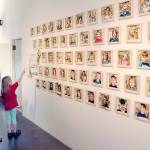 KEITH THORPE/PENINSULA DAILY NEWS
Janel Bistrika of Port Angeles and her daughter, Amelia Bistrika, 7, look at a wall of photographs of first-grade students, including Amelia, who took part in the garden-themed "Blooming Artists" exhibition during an opening reception on Tuesday at the Port Angeles Fine Arts Center. "Blooming Artists" features the works of about 275 youngsters and will run through June 25.