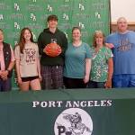 From left, grandfather Robert Elofson, sister Shyanne Austin, Tyler Hunter, mother Tammy Hunger, grandmother Barbara Sellers and dad Jason Hunter all celebrate Tyler signing to play basketball for The Evergreen State University. (Pierre LaBossiere/Peninsula Daily News)