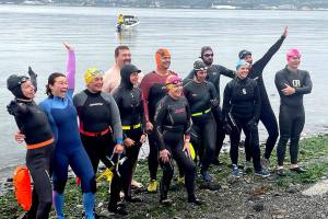 Participants in the Maritime Festivals Orca Bait Swim pump themselves up on Ediz Hook before heading out across the harbor. The inaugural event drew 12 swimmers and three orcas, whose paths did not happen to meet over the 1 1/2-mile course. (Paula Hunt/Peninsula Daily News)