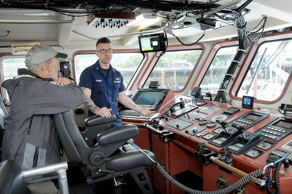 Dick Grinstad of Port Angeles, left, listens as U.S. Coast Guard Chief Warrant Officer John Elsbree describes operations of the Cutter Wahoo while moored at Port Angeles City Pier during Saturdays Maritime Festival. (Keith Thorpe/Peninsula Daily News)