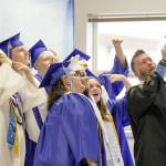 A group of graduating seniors take a selfie with teacher and head football coach Tony Haddenham while they wait for their graduation ceremony to begin on Saturday at Chimacum High School. (Steve Mullensky/for Peninsula Daily News)